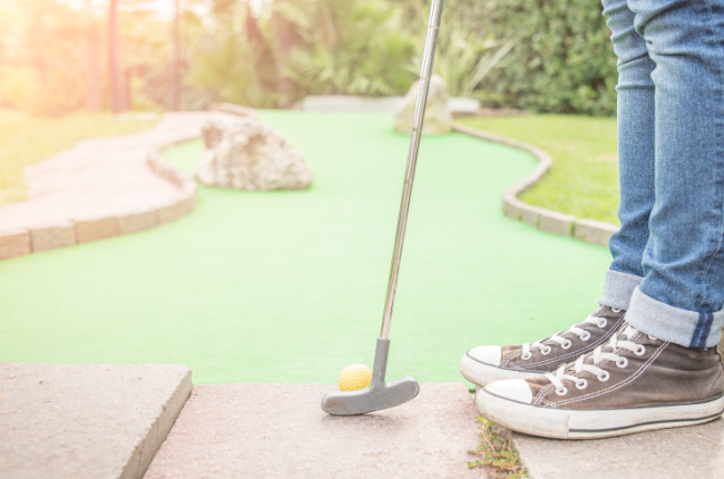 a person playing a game of mini golf