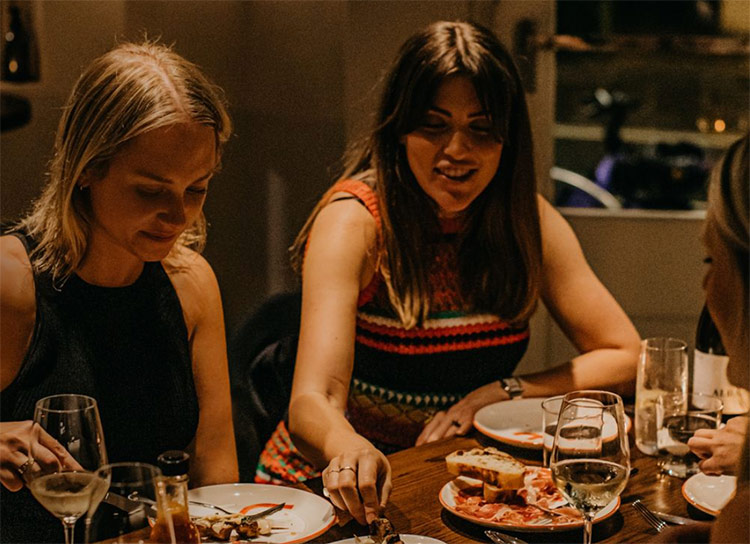 a close up of two women enjoying food at la salut bar